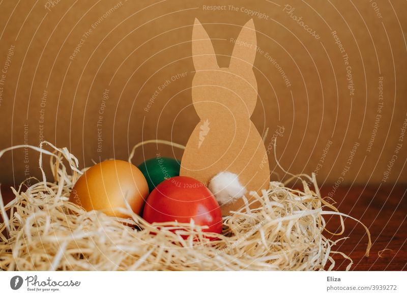 Osternest mit bunten Ostereiern und einem gebastelten Osterhasen Nest braun Hase gefärbt Eier Feste & Feiern