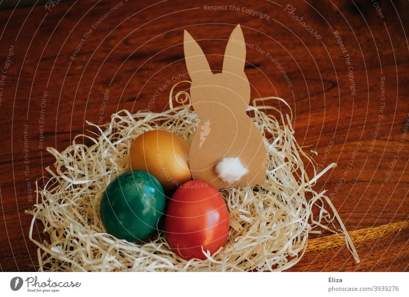 Osternest mit bunt gefärbten Eiern und einem gebastelten Osterhasen aus Papier Nest Ostereier Dekoration & Verzierung Osterdekoration Feste & Feiern
