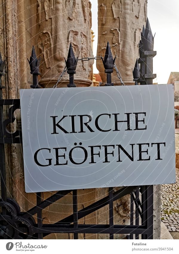 "Kirche geöffnet" steht auf einem Schild an einem schmiedeeisernen Tor. Schrift Text Wort Buchstaben Schriftzeichen Typographie Menschenleer Mitteilung