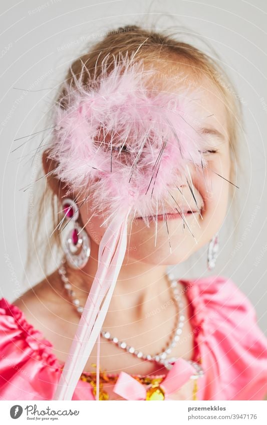 Kleines Mädchen genießt ihre Rolle der Prinzessin. Adorable niedlichen 5-6 Jahre altes Mädchen trägt rosa Prinzessin Kleid hält Zauberstab Fee Kind Stadtfest