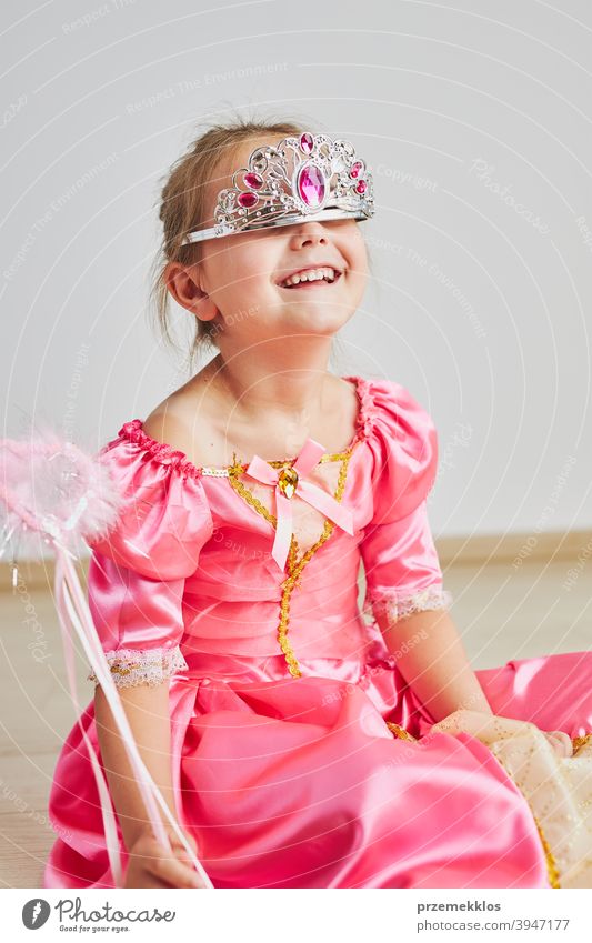 Kleines Mädchen genießt ihre Rolle der Prinzessin. Adorable niedlichen 5-6 Jahre altes Mädchen trägt rosa Prinzessin Kleid und Tiara Fee Kind Stadtfest