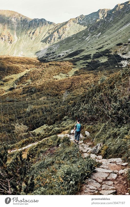 Junger Mann mit Rucksack Wandern in einem Gebirge, aktiv verbringen Sommerurlaub Aktivität Abenteuer Freiheit Gesundheit Freude Freizeit Natur Park Erholung