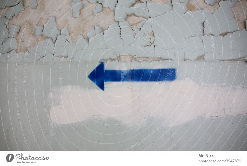 blauer Pfeil auf Wand Richtung richtungweisend Orientierung Zeichen Ziel nach links abblättern Mauer grau Renovieren dreckig Symbole & Metaphern Betonwand