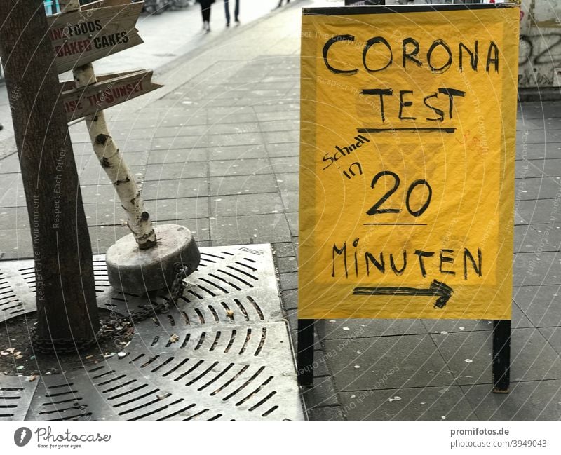 Wegweiser zum Corona-Test mit Ergebnis innerhalb von 20 Minuten. Foto: Alexander Hauk Schild gelb Aufsteller Passantenstopper Außenaufnahme Zeit Krankheit