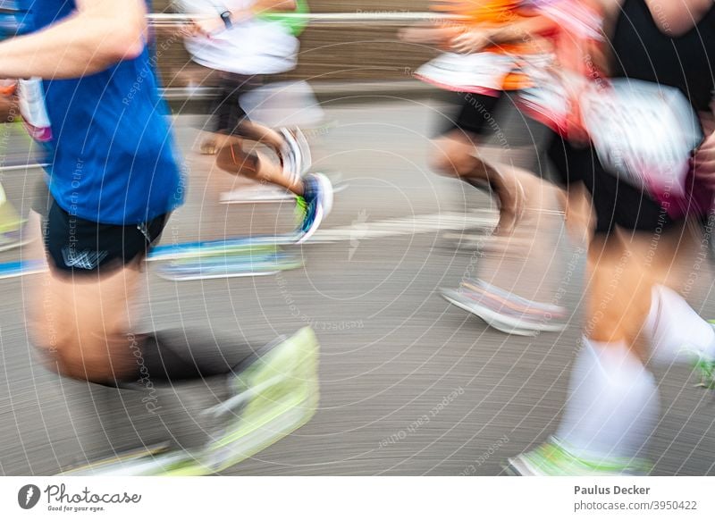 verwischte Marathonläufer auf einer Asphaltstraße Läufer joggingschuhe Jogging Geschwindigkeit Ausdauer Joggen rennen Jogger Bewegung Außenaufnahme Wettkampf
