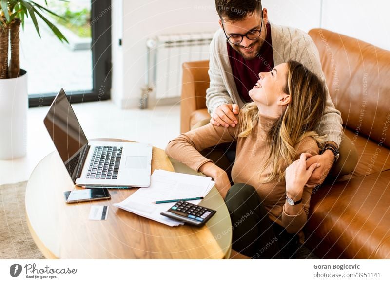Junges Paar mit Laptop zusammen, während auf dem Sofa zu Hause sitzen Frau Mann Internet Glück Computer im Innenbereich Menschen heimwärts Kaukasier Liege Raum