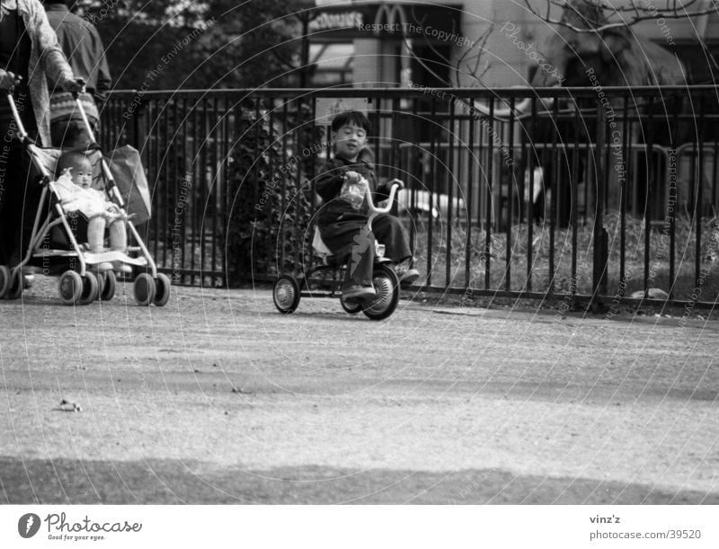 Dreirad im Jardin des Plantes Paris Kind Park Mann Schwarzweißfoto Asien