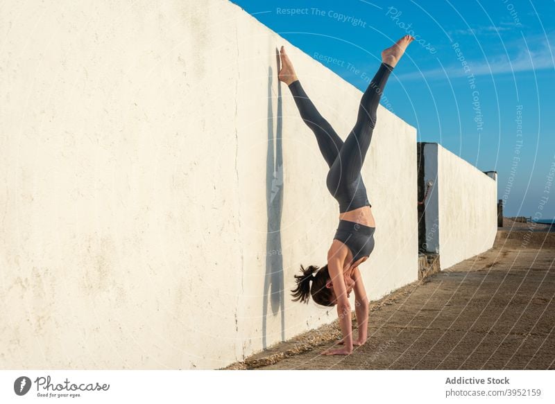Schlanke Frau macht Yoga im Handstand Position in der Nähe der Wand üben Asana Harmonie Gleichgewicht beweglich Zen fettarm Wellness schlank Achtsamkeit
