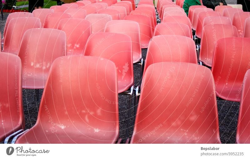 Rote alte Plastikstühle Reihe Sitz Stuhl Nahaufnahme Publikum Tagung Möbel Perspektive Sitzgelegenheit Zuschauerin leer Veranstaltung viele Öffentlich Linie
