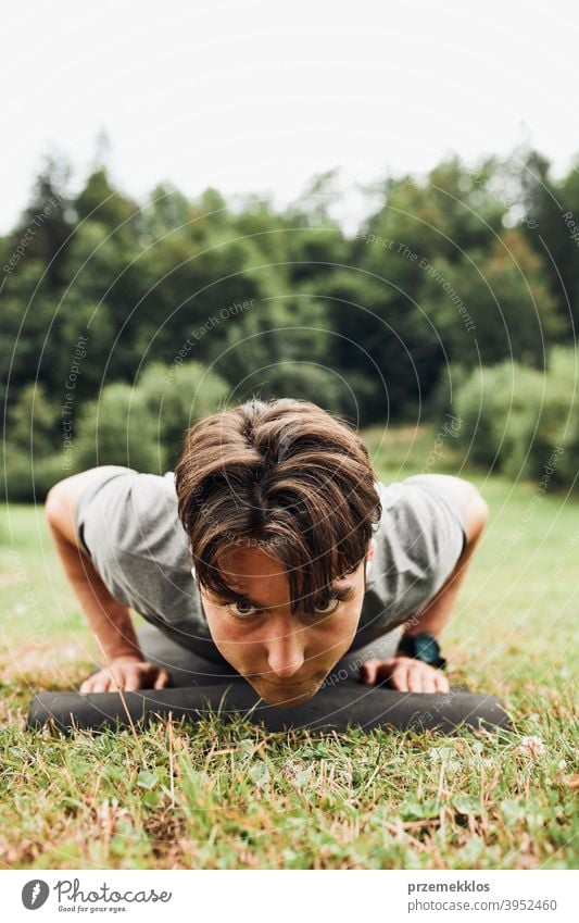 Junger Mann macht Liegestütze draußen auf Gras während seines Calisthenics-Trainings aktiv Aktivität Athlet sportlich Körper Bodybuilder Bodybuilding