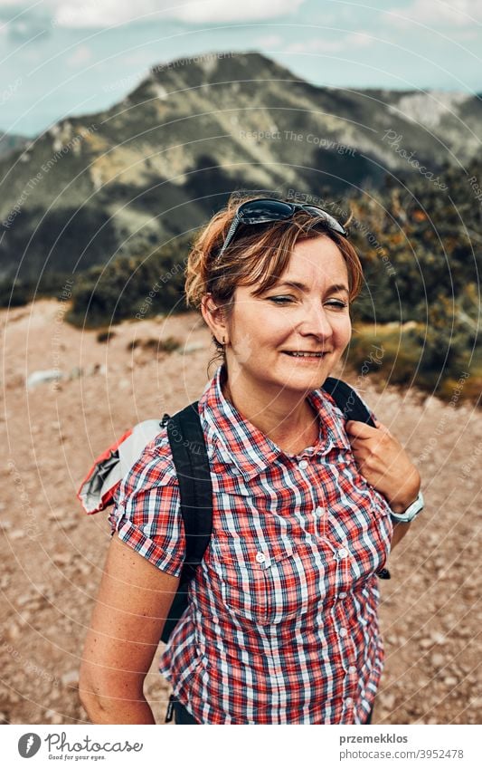 Lächelnde glückliche Frau mit Rucksack Wandern in einem Gebirge, aktiv verbringen Sommerurlaub Aktivität Abenteuer Freiheit Spaß grün Gesundheit Freude Freizeit