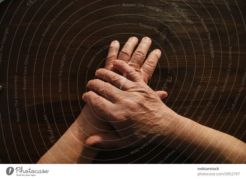 Hände und Arme eines alten Mannes auf einer hölzernen Oberfläche Hand Finger männlich Hochwinkelansicht nicht erkennbare Person Glied im Innenbereich