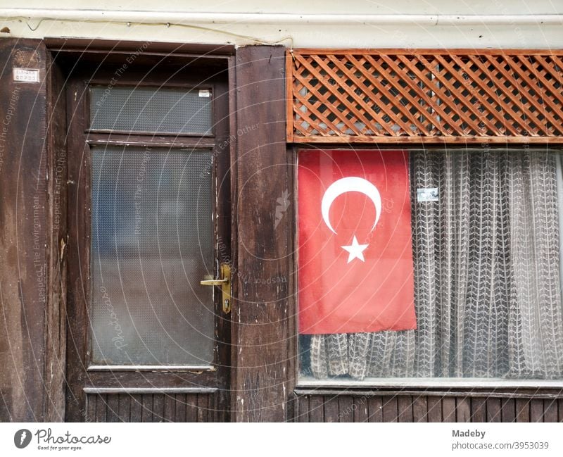 Die türkische Fahne im Schaufenster eines kleinen alten Geschäft mit Gardine in Göynük in der Provinz Bolu in der Türkei Flagge Nationalismus Nationalstolz
