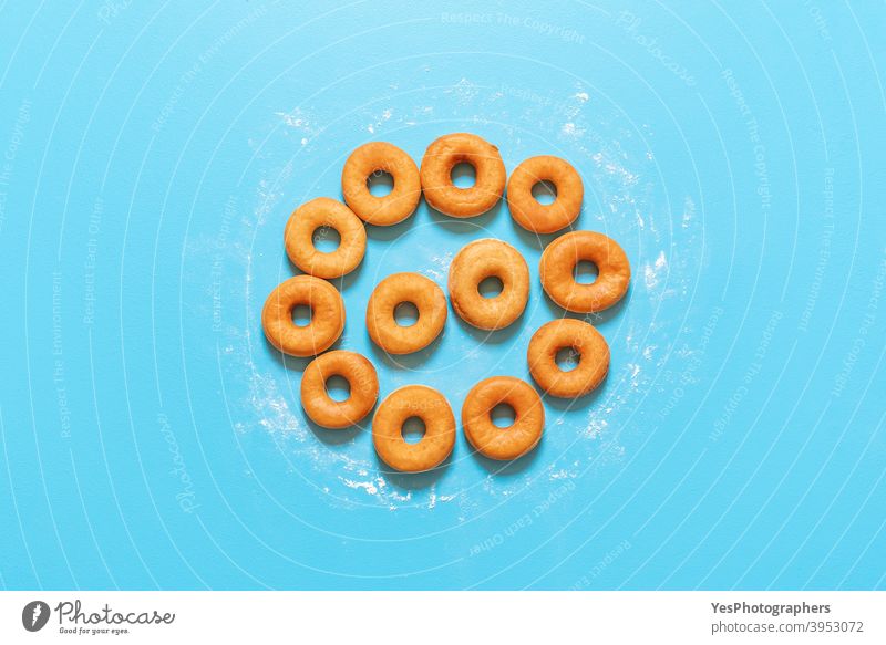 Donuts in einer Kreisform ausgerichtet. Hausgemachte frische Krapfen, Ansicht von oben Amerikaner gebacken Bäckerei Blauer Hintergrund Frühstück Kuchen Kalorien