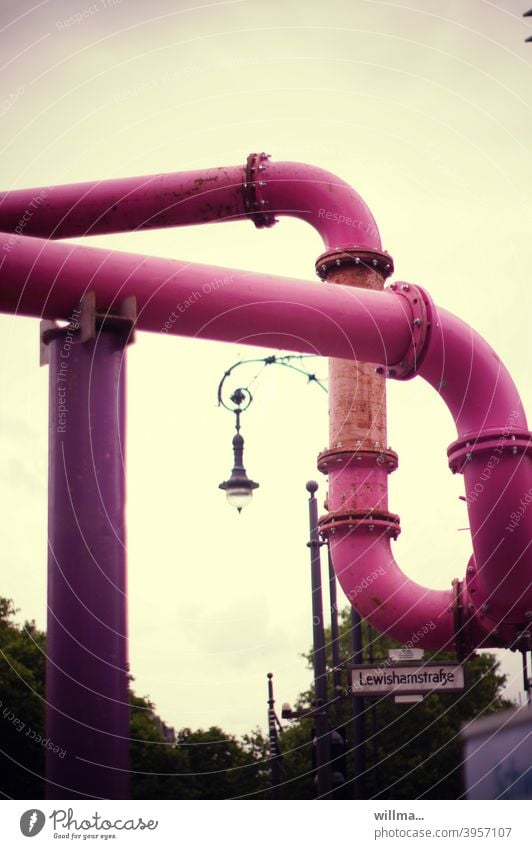 Berliner Bandwurm in pink - freiliegend und sich vor Lachen biegend - schmückt sich mit nostalgischer Straßenlaterne Rohre Wasserrohre Rohrsystem rosa
