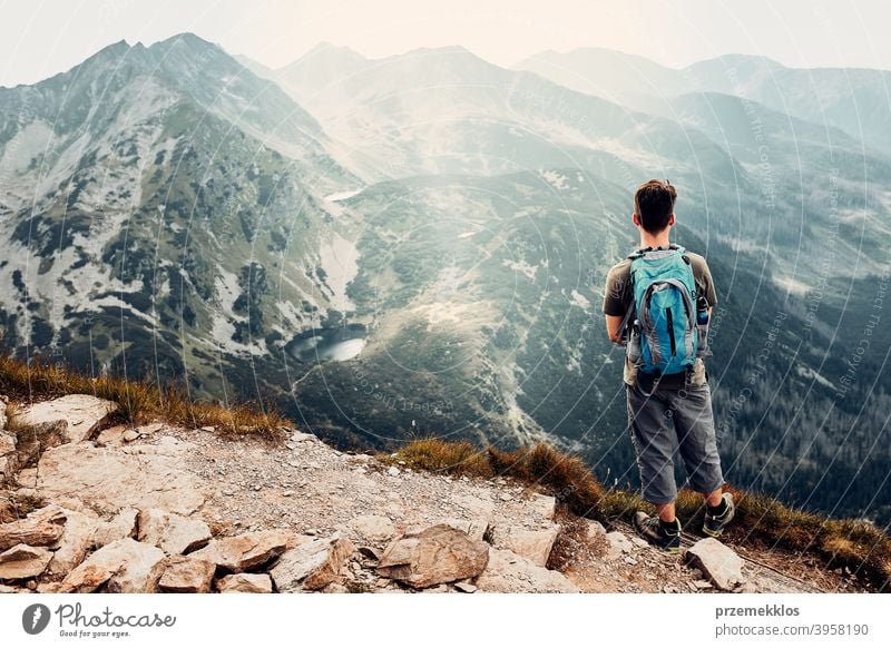 Junger Mann mit Rucksack Wandern in einem Gebirge, aktiv verbringen Sommerurlaub Aktivität Abenteuer Freiheit Gesundheit Freude Freizeit Natur Park Erholung