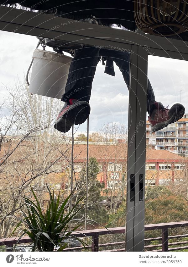 Unbekannter Bergsteiger putzt Fenster eines Gebäudes industriell Alpinismus Sauberkeit Alpinist Waschen Glas wohnbedingt hängen Haus Außenseite Fassade Arbeit