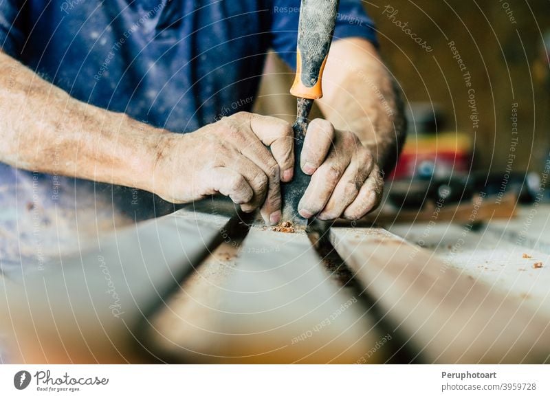 Professioneller Schreiner bei der Arbeit, er schnitzt Holz mit einem Holzbearbeitungswerkzeug, Hände Nahaufnahme, Zimmerei und Handwerkskunst Konzept