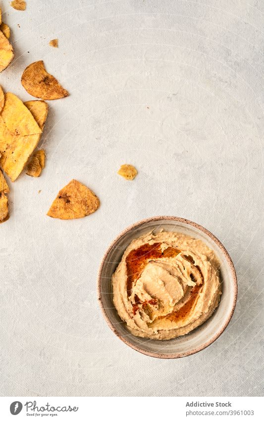 Hummus und Kartoffelchips auf dem Tisch Kichererbsen Schalen & Schüsseln Speise gestampft Chip Dip geschmackvoll lecker Knusprig Lebensmittel Mahlzeit Snack