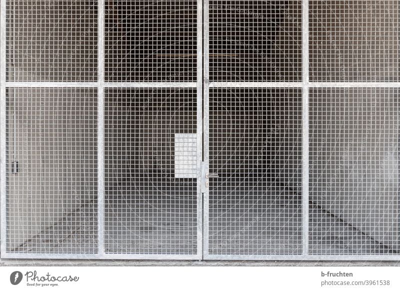 leerer Lagerraum hinter verschlossener Gittertür Tor Tür Gittertor Raum Eingang geschlossen Ausgang Griff Eingangstür Strukturen & Formen Metall