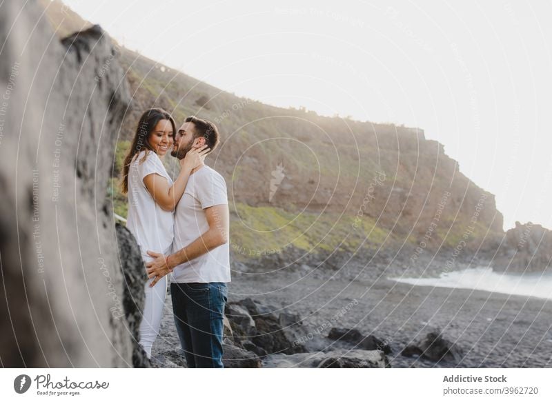 Liebendes Paar, das sich am felsigen Meeresufer umarmt MEER romantisch Umarmen Kuss Küste Strand Zusammensein Zuneigung Glück jung Teneriffa Insel Kanarienvogel