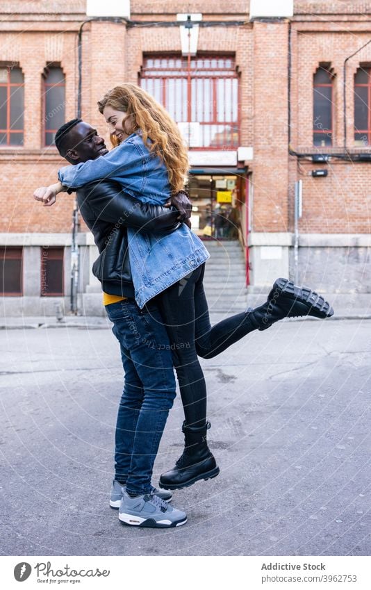 Glückliches multirassisches Paar, das sich in der Stadt umarmt kuscheln Straße Zusammensein Freund Freundin Großstadt Liebe Partnerschaft Zuneigung