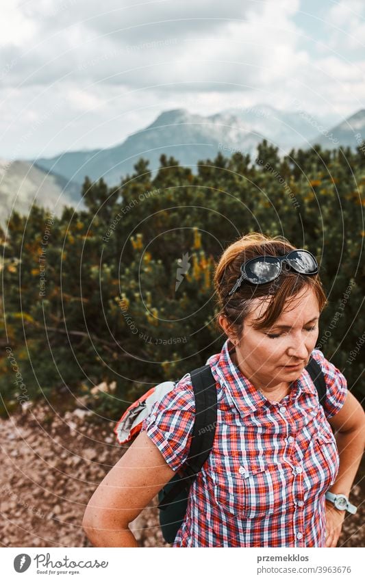 Frau mit Rucksack Wandern in einem Gebirge, aktiv verbringen Sommerurlaub, mit Pause nach dem Gehen auf einem Hügel Aktivität Abenteuer Freiheit grün Gesundheit