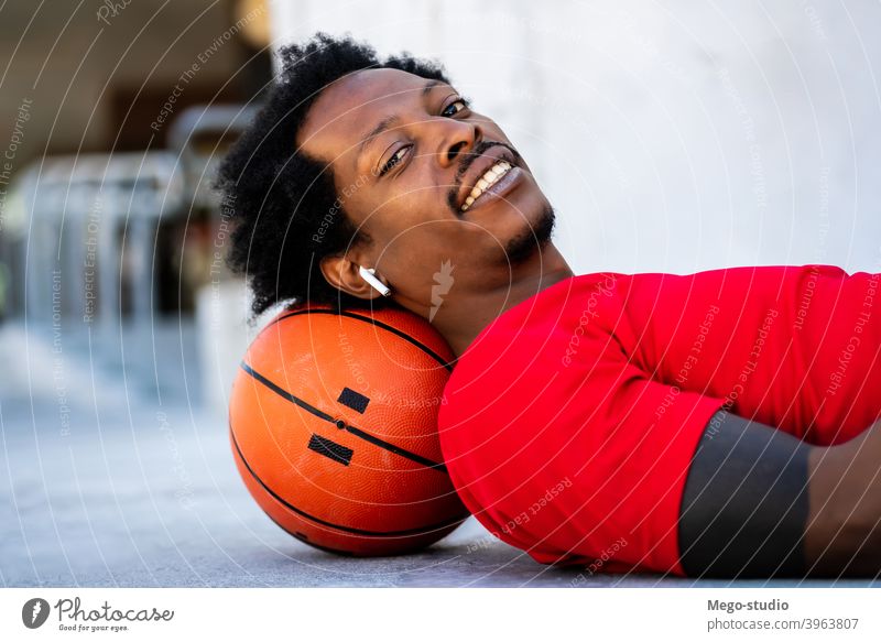 Afro-Athlet Mann auf dem Boden liegend nach dem Training. Sport Basketball Ball urban sportlich im Freien Stehen genießen Ausdruck aktiv Hand Übung Erholung