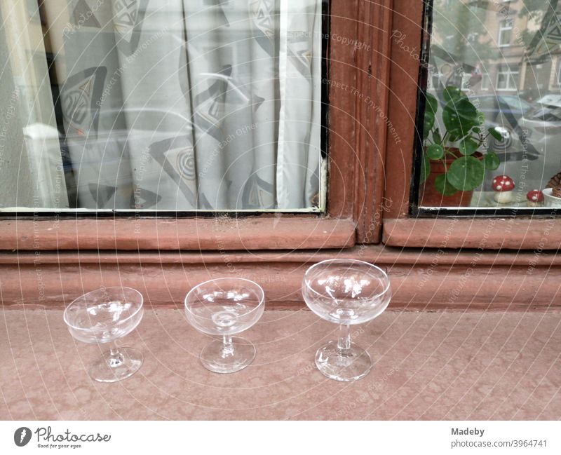 Leere Gläser und Likörschalen auf der Fensterbank eines Altbau mit Holzfenster und Gardine im Nordend von Frankfurt am Main in Hessen Likörglas Glas Stillleben