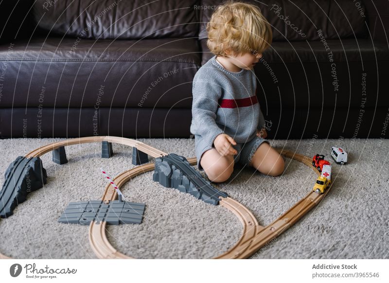 Kleiner Junge spielt mit Spielzeugbahn Kind spielen Straße Bahn zu Hause Aktivität wenig Kindheit Lifestyle Vorschule Freizeit kreativ Kinderbetreuung errichten