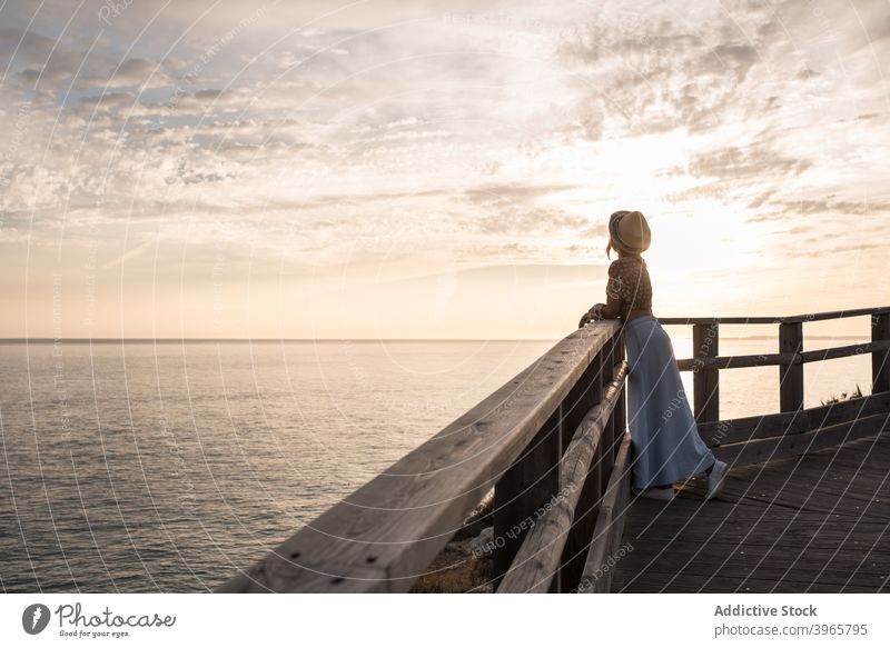 Anonyme weibliche Touristin genießt die Meereslandschaft, während sie sich auf der Holzpromenade erholt Frau sich[Akk] entspannen Pier bewundern MEER