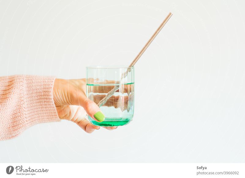 Frau hält Getränk mit wiederverwendbarem Stahlstrohhalm keine Verschwendung Stroh kunststofffrei Hand Glas Pastell rostfrei Minze grün trinken Mode urban Wasser