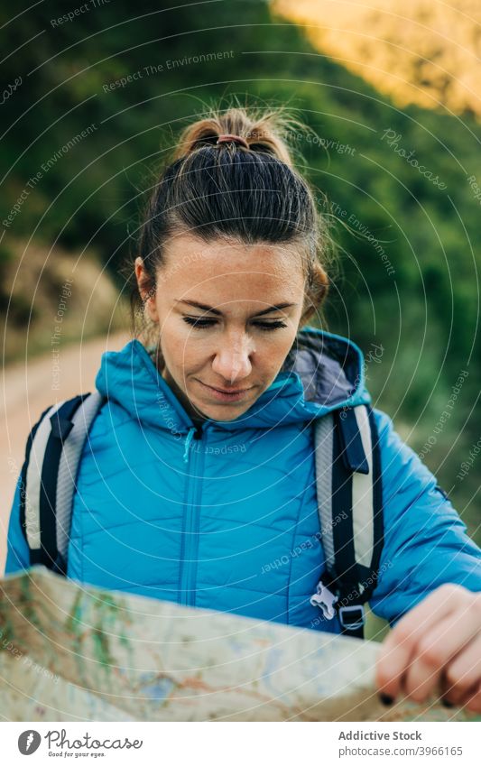 Frau liest Papierkarte beim Wandern lesen Landkarte sich orientieren navigieren Trekking Örtlichkeit finden Wanderer Natur Abenteuer warm Jacke warme Kleidung