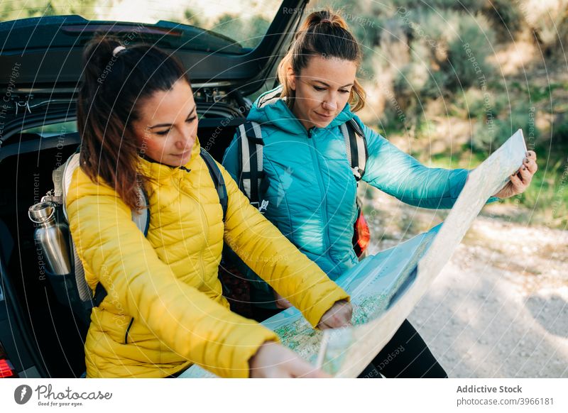 Reisende Frauen mit Papierkarte in der Nähe von Auto navigieren Landkarte Suche PKW Route Reisender Zusammensein sich orientieren reisen Tourismus Ausflug