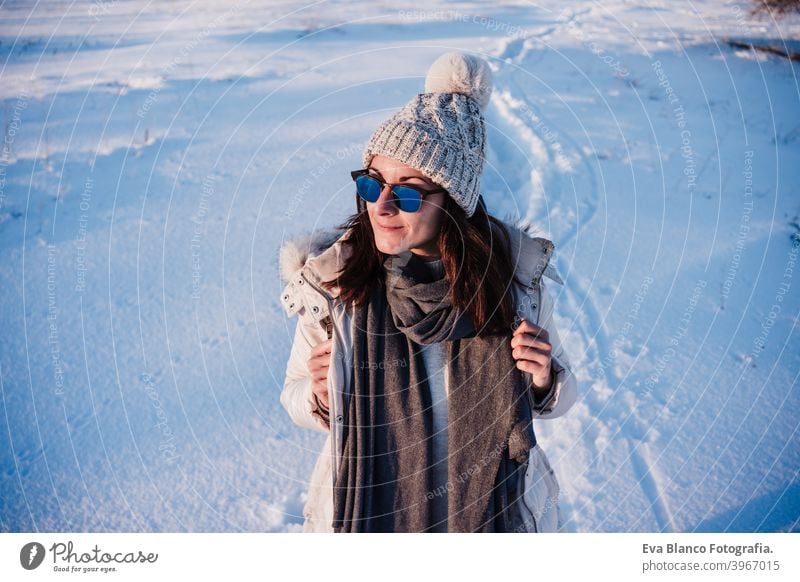 glückliche junge Frau Wandern in verschneiten Berg trägt modernen Mantel bei Sonnenuntergang. Wintersaison. Natur Schnee Berge u. Gebirge wandern kalt Kaukasier