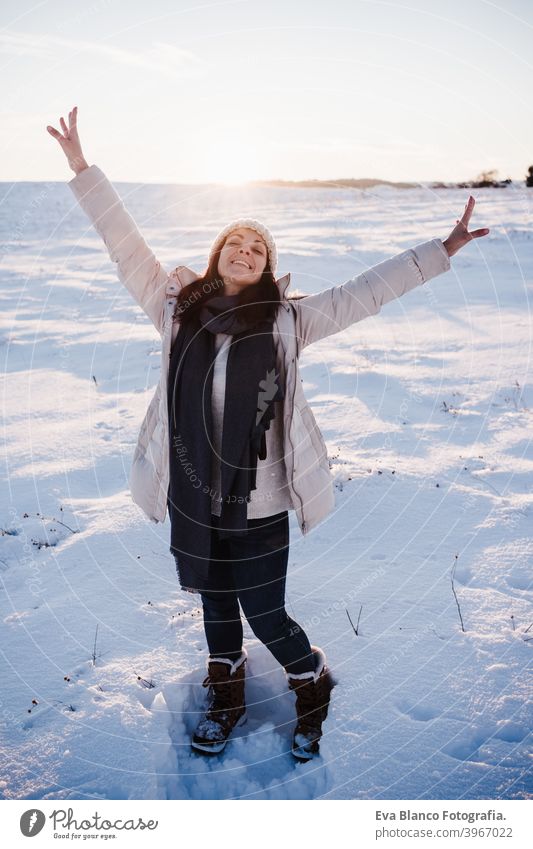 glückliche junge Frau Wandern in verschneiten Berg trägt modernen Mantel bei Sonnenuntergang. Wintersaison. Natur Schnee Berge u. Gebirge wandern kalt Kaukasier