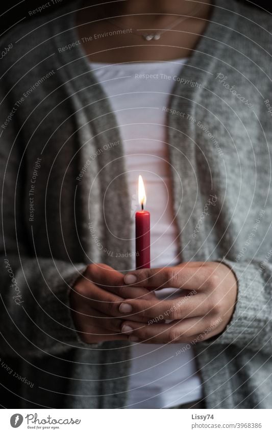 Eine einzelne rote, brennende Kerze gehalten von einem Mädchen Kerzenflamme Hände in den Händen  halten Licht andächtig gemütlich Wärme Advent Weihnachten