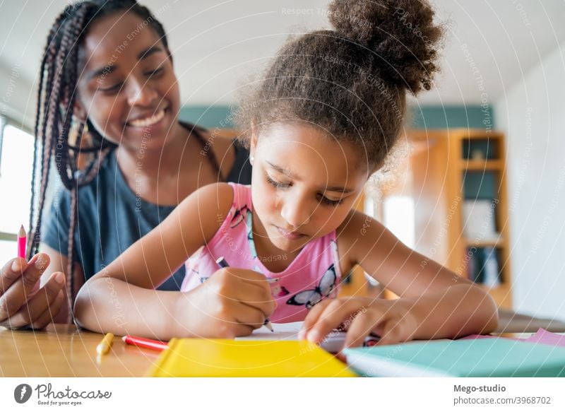 Ein Vater hilft seiner Tochter bei der Hausaufgabenbetreuung. Mutter Heimschule Schüler Lernen Lifestyle Quarantäne Familie Kinder Menschen absperren