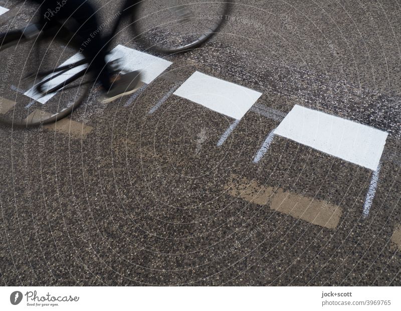 Radfahrer fährt über die frisch aufgemalte Straßenmakierung Fahrbahnmarkierung Verkehrswege Asphalt Verkehrszeichen neu Verkehrsleitkegel Strichellinie