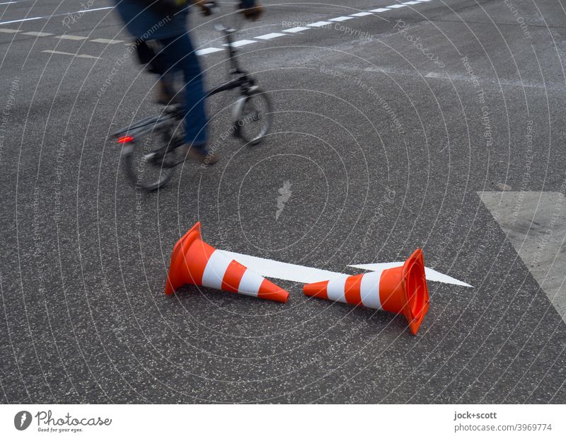 Leitkegel leitet Radfahrer um den frisch aufgemalten weißen Pfeil herum Fahrbahnmarkierung Verkehrswege Asphalt Straße Richtung Verkehrszeichen Orientierung neu