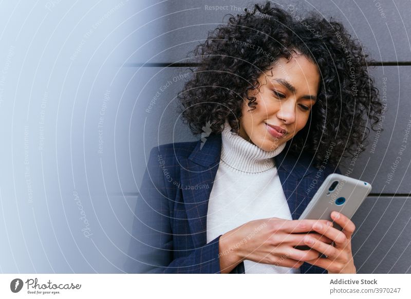 Junge ethnische Frau beim Surfen auf dem Smartphone Geschäftsfrau benutzend Browsen Mobile Telefon Apparatur jung Kommunizieren online lesen positiv