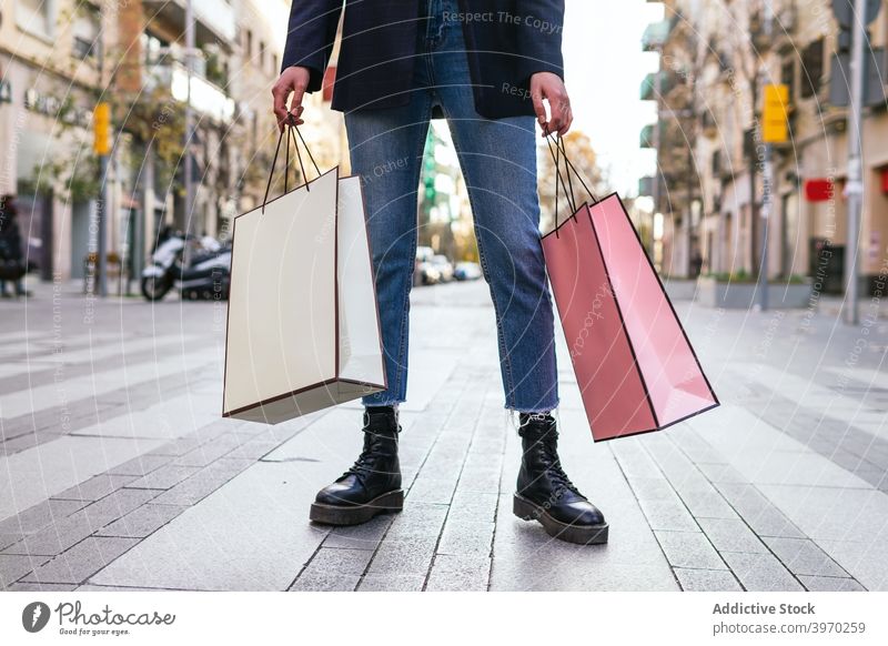 Crop Frau mit Einkaufstaschen auf der Straße Tüte Großstadt Käufer Konsumverhalten Kunde konsumgeil Kauf Papier Tasche Sale Einzelhandel Rabatt trendy Stil