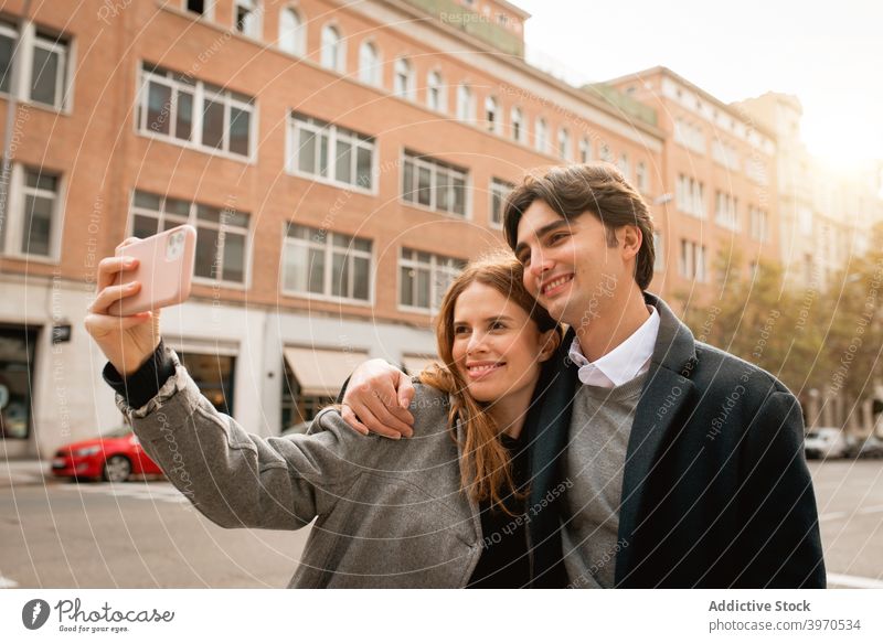 Verliebtes junges Paar nimmt Selfie auf der Straße Liebe Zusammensein Glück Smartphone Partnerschaft Umarmen Freundin heiter Lifestyle romantisch Zuneigung