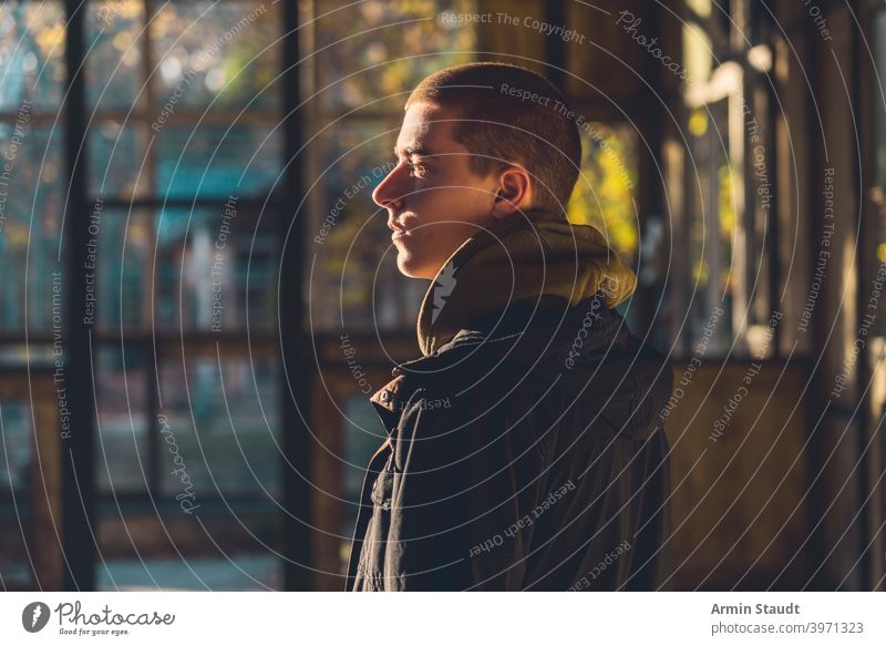 Porträt eines jungen Mannes im Profil mit Abendsonne Sonnenlicht Kapuzenpulli Rahmen Gebäude Ruine Sonnenuntergang Windstille stumm sich[Akk] entspannen