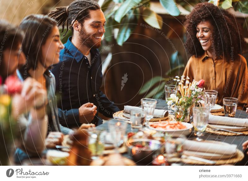 glückliche Gruppe von Freunden sitzen am Tisch beim Abendessen zusammen Erwachsener offen im Freien junger Erwachsener Alkohol Hinterhof zu feiern plaudernd
