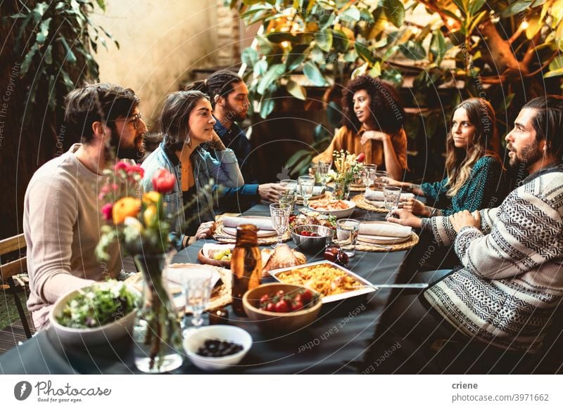 Gruppe von erwachsenen Freunden beim Abendessen Gartenparty zusammen beim Abendessen Erwachsener offen im Freien junger Erwachsener Alkohol Hinterhof zu feiern