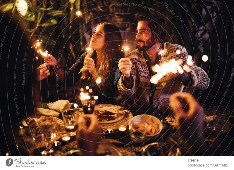 Junges erwachsenes Paar feiert mit Wunderkerzen auf einer gemeinsamen Dinnerparty 4. Juli offen Datierung Fröhlichkeit Heterosexuelles Paar Menschen Lächeln