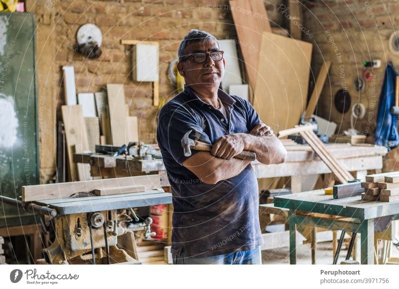 Porträt eines älteren Schreiners in seiner Werkstatt und mit Blick in die Kamera. Zimmerer Senior Schreinerei Kunsthandwerker männlich Beruf Menschen arbeiten