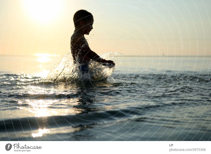 glückliches Kind im Meer bei Sonnenuntergang spielen mit Wasser Glaube und Religion Hintergrund weitergeben Arme Hand Zufriedenheit Tanzen Körperhaltung