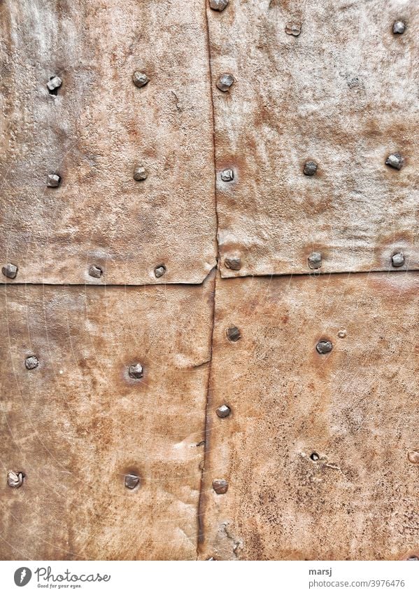 Zeitgeschichte | 4 genietete, rostige Blechtafeln, die eine Tür oder Fassade vor Einbrechern und Witterung schützen Patchwork Handwerk flicken Kontrast